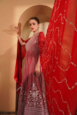 Red embroidered gown with silver & white detailing and long cape sleeves.
