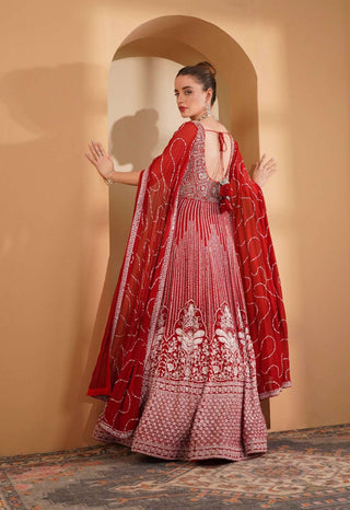 Red gown with silver-white embroidery and flowing cape sleeves.