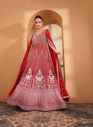Red gown with silver & white embroidery, featuring long cape sleeves.