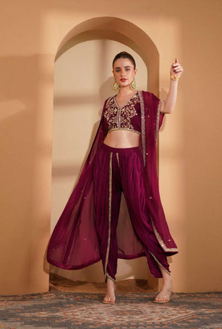 Wine crepe blouse with pearl and mirror work, paired with mirror border tulip pants.