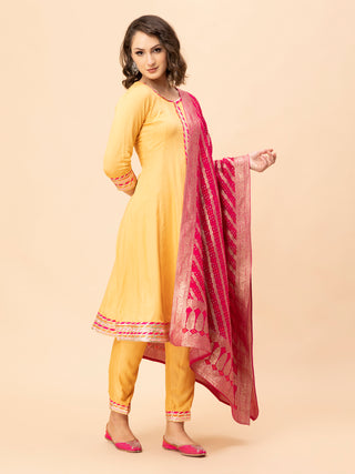 Peach Anarkali suit with multi-color border, brocade dupatta, and pants.